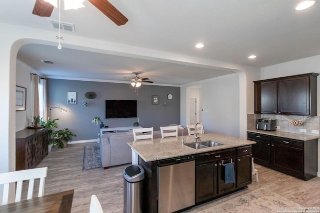 kitchen featuring sink, backsplash, stainless steel dishwasher, dark brown cabinets, and a center island with sink