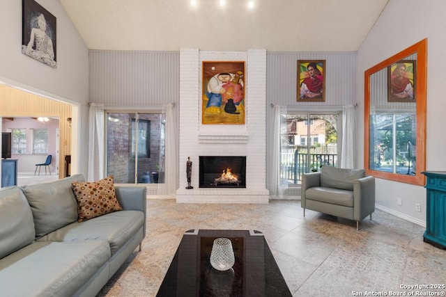 living room featuring high vaulted ceiling and a brick fireplace