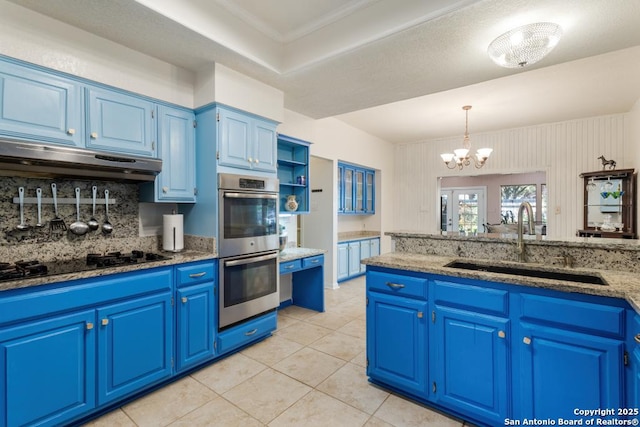 kitchen featuring sink, hanging light fixtures, range hood, a notable chandelier, and blue cabinets