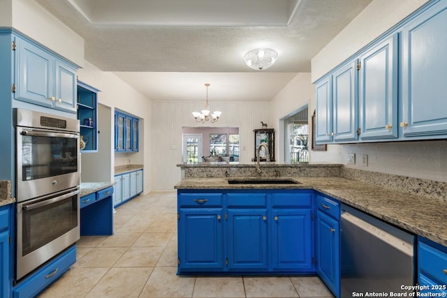 kitchen with sink, kitchen peninsula, blue cabinetry, and appliances with stainless steel finishes