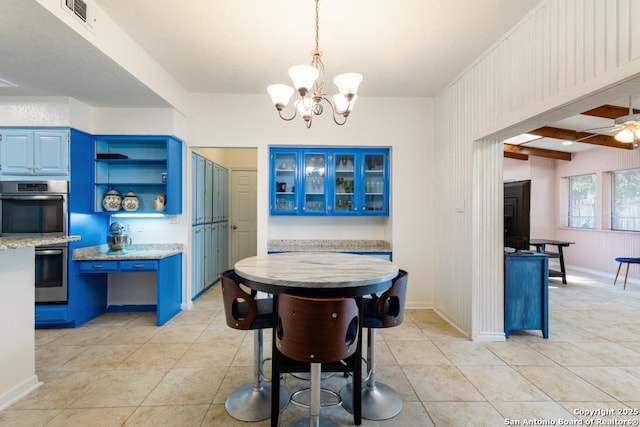 dining area featuring beamed ceiling, ceiling fan with notable chandelier, and light tile patterned flooring