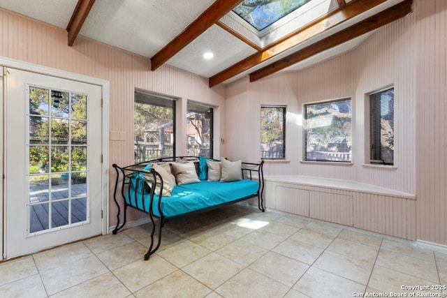 sunroom / solarium featuring beamed ceiling and a skylight