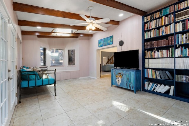 interior space with beam ceiling, ceiling fan, and light tile patterned flooring