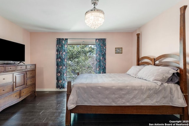 bedroom featuring a notable chandelier and dark hardwood / wood-style flooring