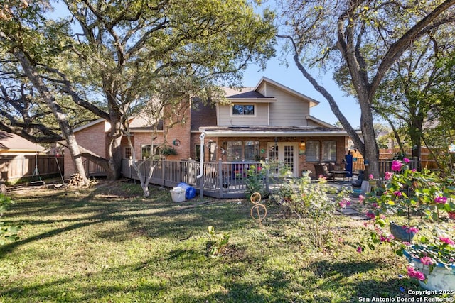 back of property featuring a yard and a deck