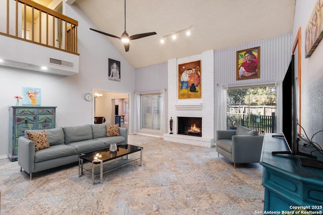 living room featuring ceiling fan, high vaulted ceiling, and a brick fireplace