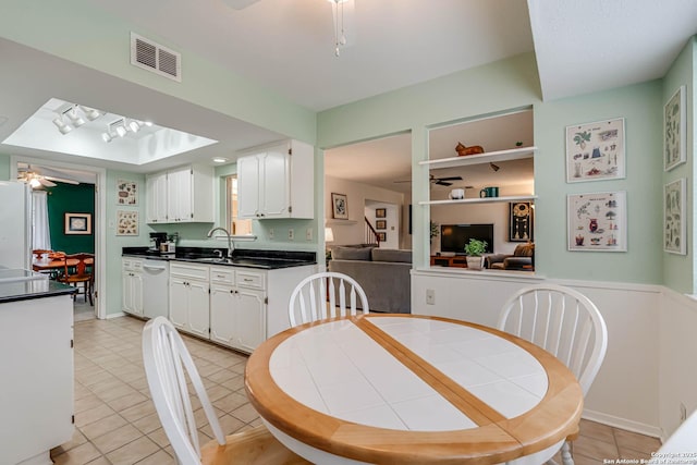 kitchen with white cabinets, ceiling fan, sink, light tile patterned flooring, and white dishwasher