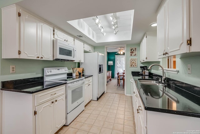 kitchen with white cabinetry, sink, white appliances, and light tile patterned flooring