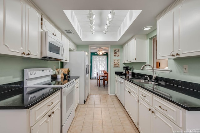 kitchen with sink, white cabinets, a tray ceiling, and white appliances