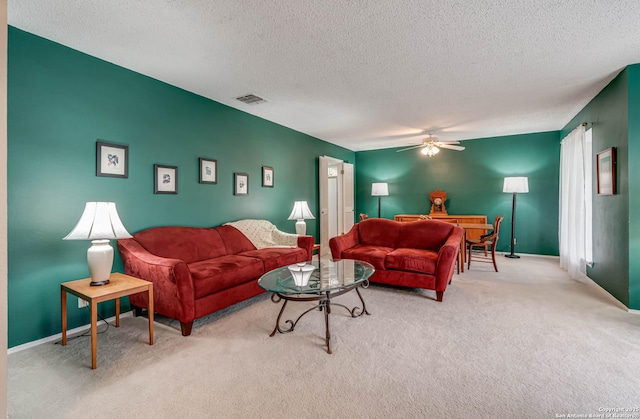 carpeted living room with ceiling fan and a textured ceiling