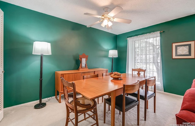 dining area featuring a textured ceiling, ceiling fan, and light colored carpet