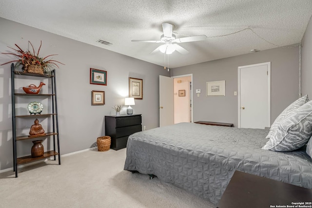 carpeted bedroom with ceiling fan and a textured ceiling