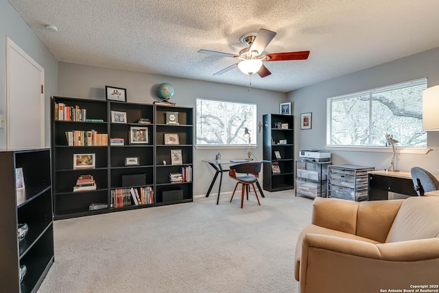 living area with a textured ceiling, ceiling fan, and carpet flooring