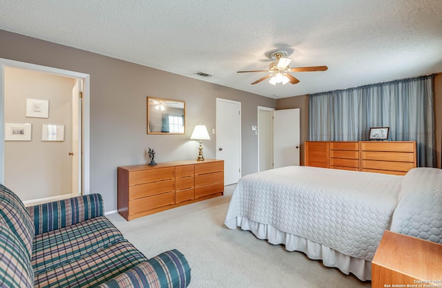 bedroom featuring a textured ceiling, ceiling fan, and light carpet