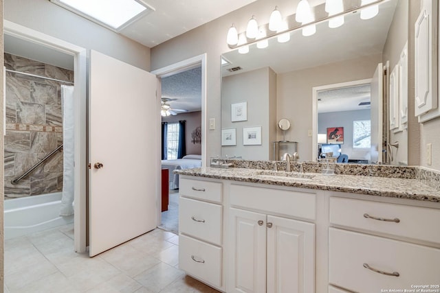 bathroom with ceiling fan, a textured ceiling, vanity, and shower / bathtub combination with curtain