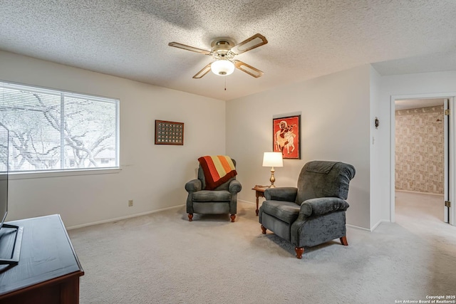 sitting room with a textured ceiling, ceiling fan, and light colored carpet