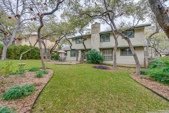 rear view of property with a patio and a yard