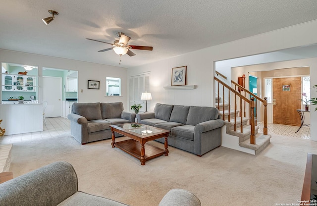 carpeted living room with ceiling fan and a textured ceiling