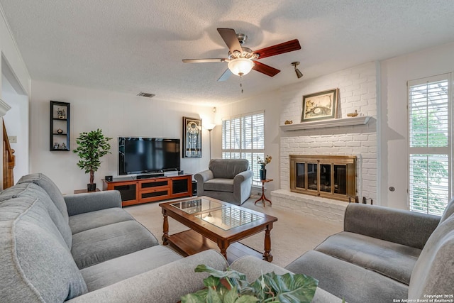 living room featuring a textured ceiling, a fireplace, and plenty of natural light