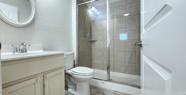 bathroom featuring vanity, toilet, and a shower with door