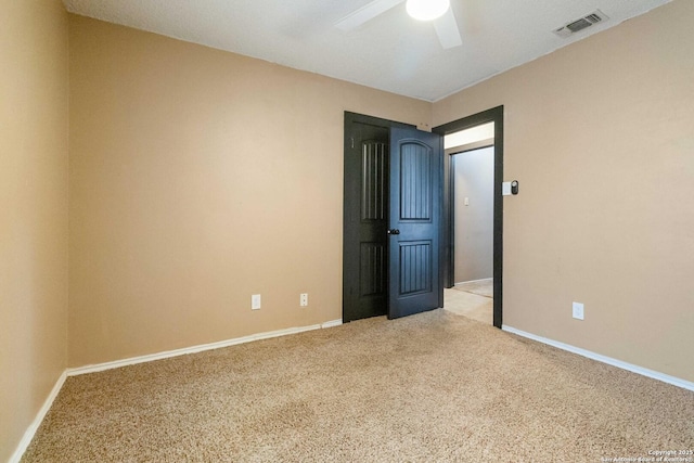 carpeted spare room featuring ceiling fan