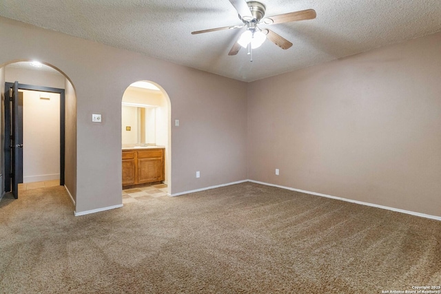 carpeted empty room with a textured ceiling and ceiling fan