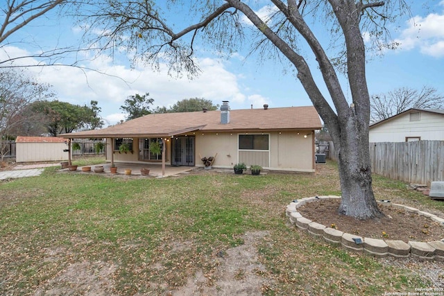 rear view of property with a yard and a patio area