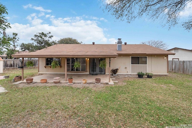 back of property with a yard and a patio area