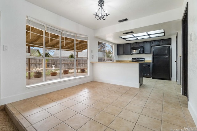 kitchen with a notable chandelier, light tile patterned floors, black appliances, and kitchen peninsula