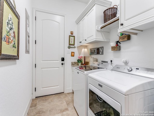 clothes washing area with cabinets and washing machine and clothes dryer