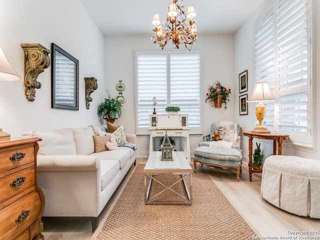 sitting room with hardwood / wood-style floors and an inviting chandelier