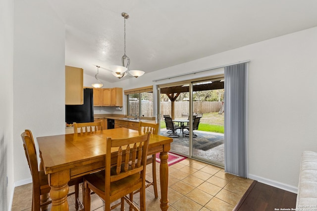 dining area with light tile patterned flooring, sink, and vaulted ceiling