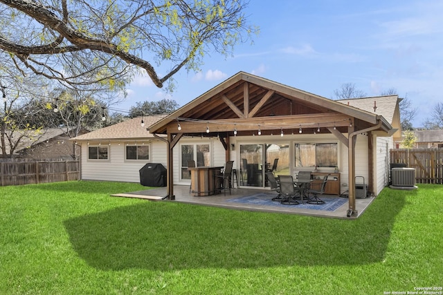 rear view of property featuring central air condition unit, a yard, and a patio