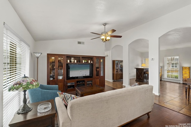 living room with vaulted ceiling, ceiling fan, and dark wood-type flooring