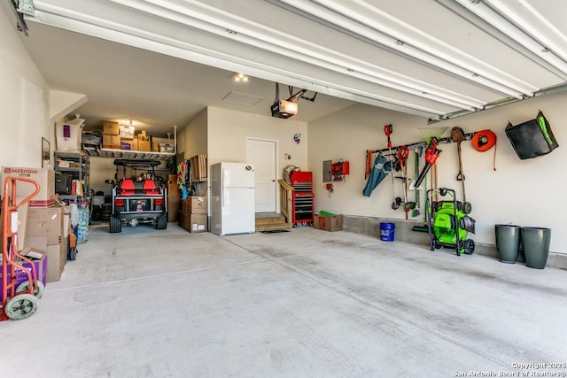 garage with white fridge and a garage door opener