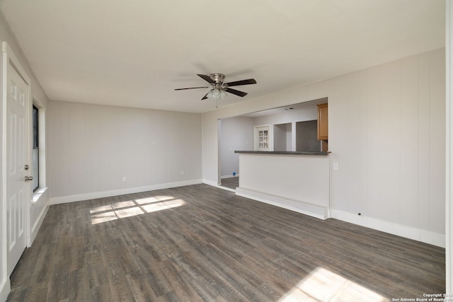 unfurnished living room with dark hardwood / wood-style floors and ceiling fan