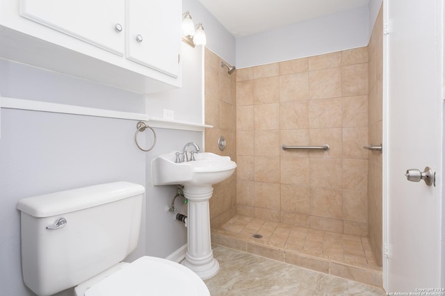 bathroom featuring toilet and a tile shower