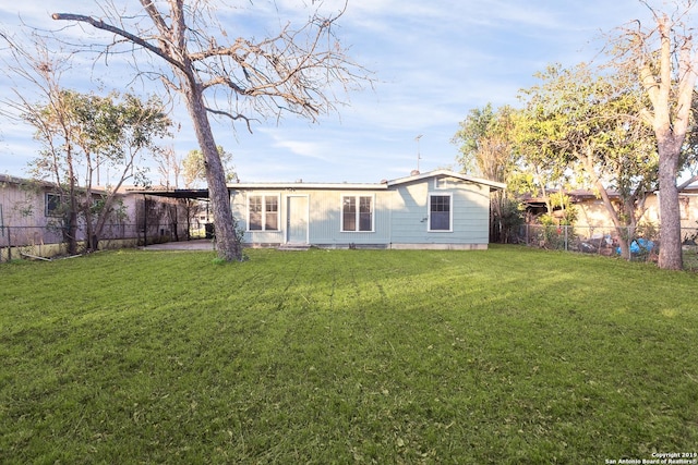 back of house featuring a lawn