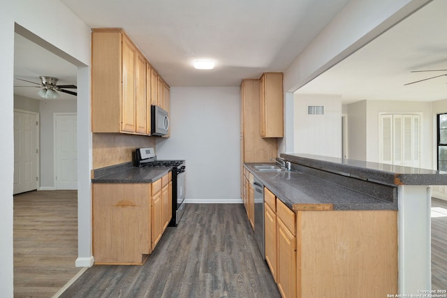 kitchen featuring sink, light brown cabinets, dark hardwood / wood-style floors, kitchen peninsula, and appliances with stainless steel finishes