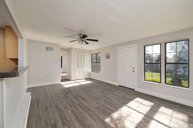 unfurnished living room featuring ceiling fan and dark hardwood / wood-style flooring