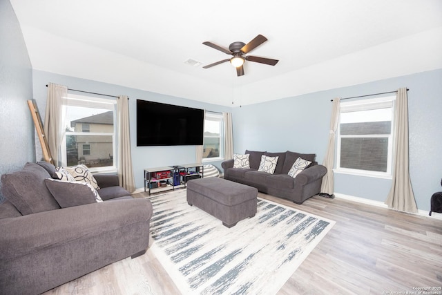 living room with a wealth of natural light, light hardwood / wood-style floors, and ceiling fan