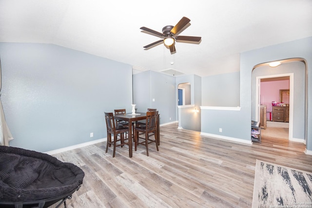 dining area featuring ceiling fan, light wood-type flooring, and vaulted ceiling