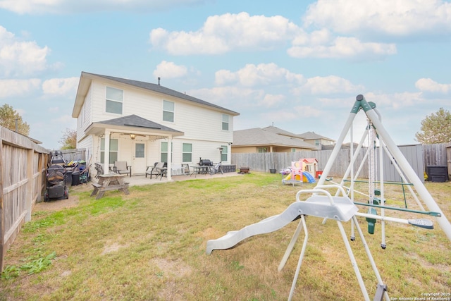 back of property featuring a playground, a patio area, and a lawn