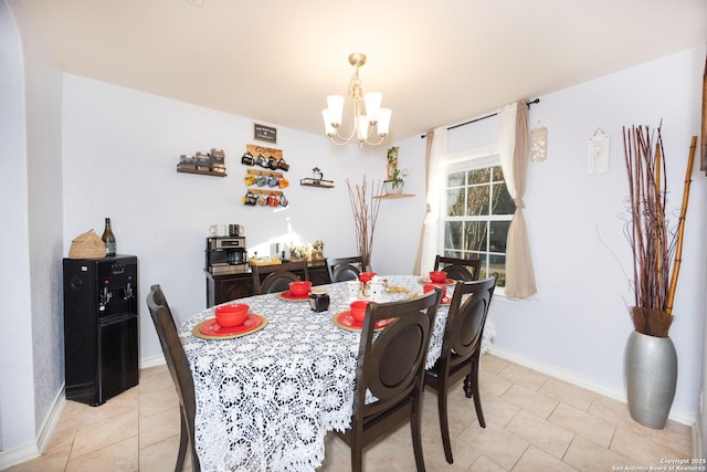 dining space with light tile patterned flooring and an inviting chandelier