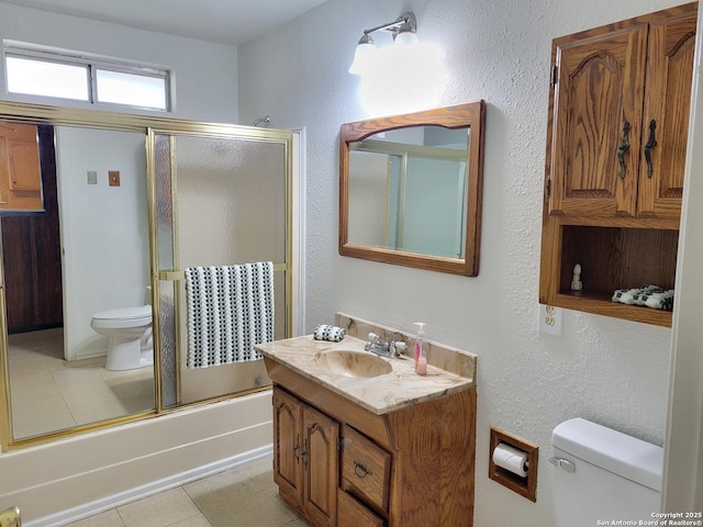 full bathroom featuring tile patterned floors, toilet, vanity, and combined bath / shower with glass door