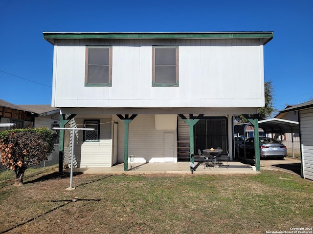 rear view of property featuring a carport and a lawn