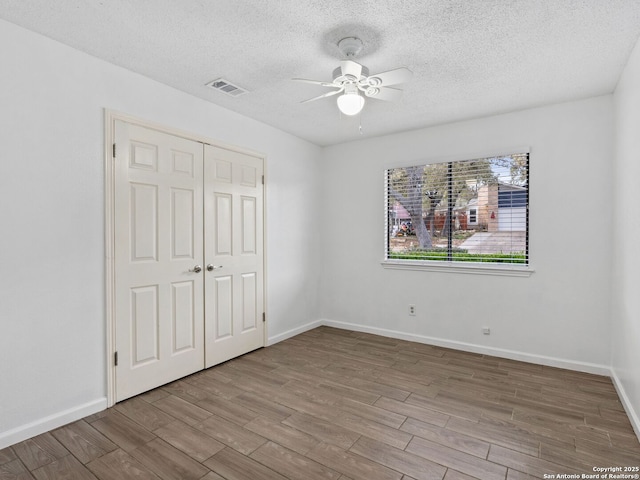 unfurnished bedroom featuring ceiling fan, a closet, and a textured ceiling