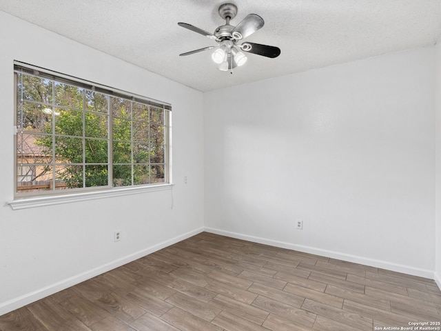 spare room featuring ceiling fan, wood-type flooring, and a textured ceiling