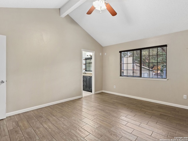 spare room with lofted ceiling with beams and ceiling fan