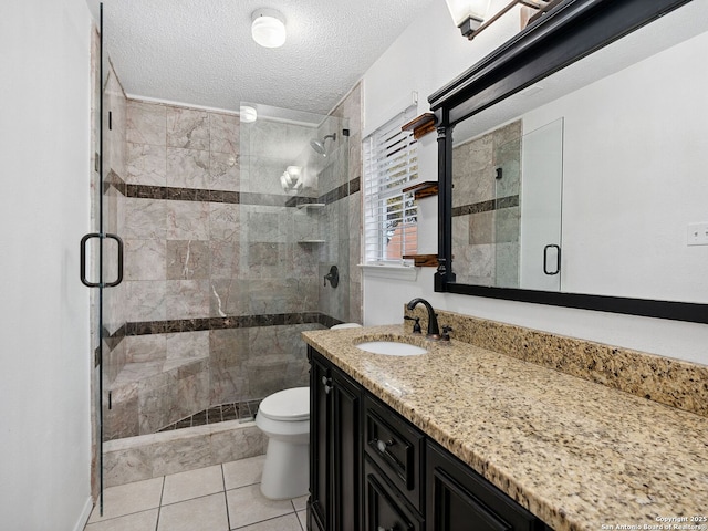 bathroom with tile patterned flooring, a textured ceiling, toilet, vanity, and a shower with shower door